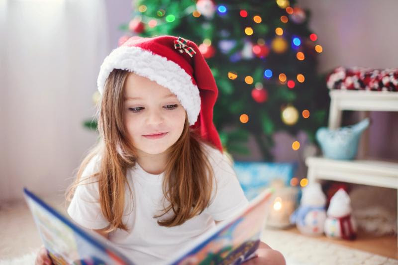 Child reading book at Christmas