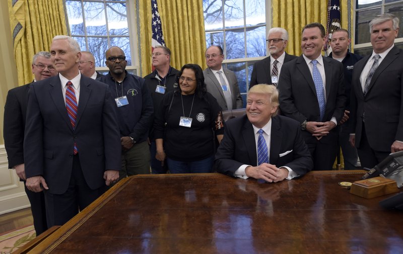 President Donald Trump's opening work day offered a look at his tricky balancing act between American businesses and the working-class voters