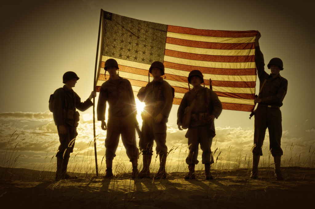 WWII Soldiers Standing In A Flag Draped Sunset - SIlhouette